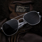 Aviator Military Special Edition - Matte Chrome sunglasses on a dark textured surface