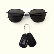 Black sunglasses with Randolph Aviators Class A dog tags on a white background